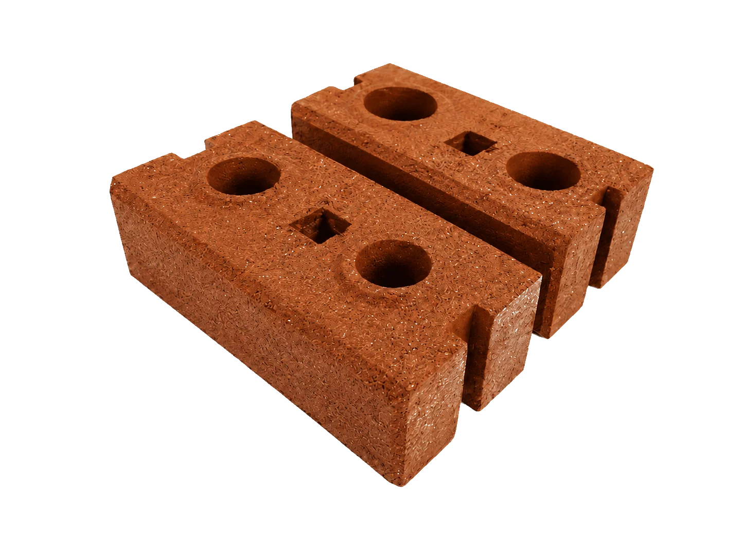 Two interlocking compressed laterite bricks, one seated on the other